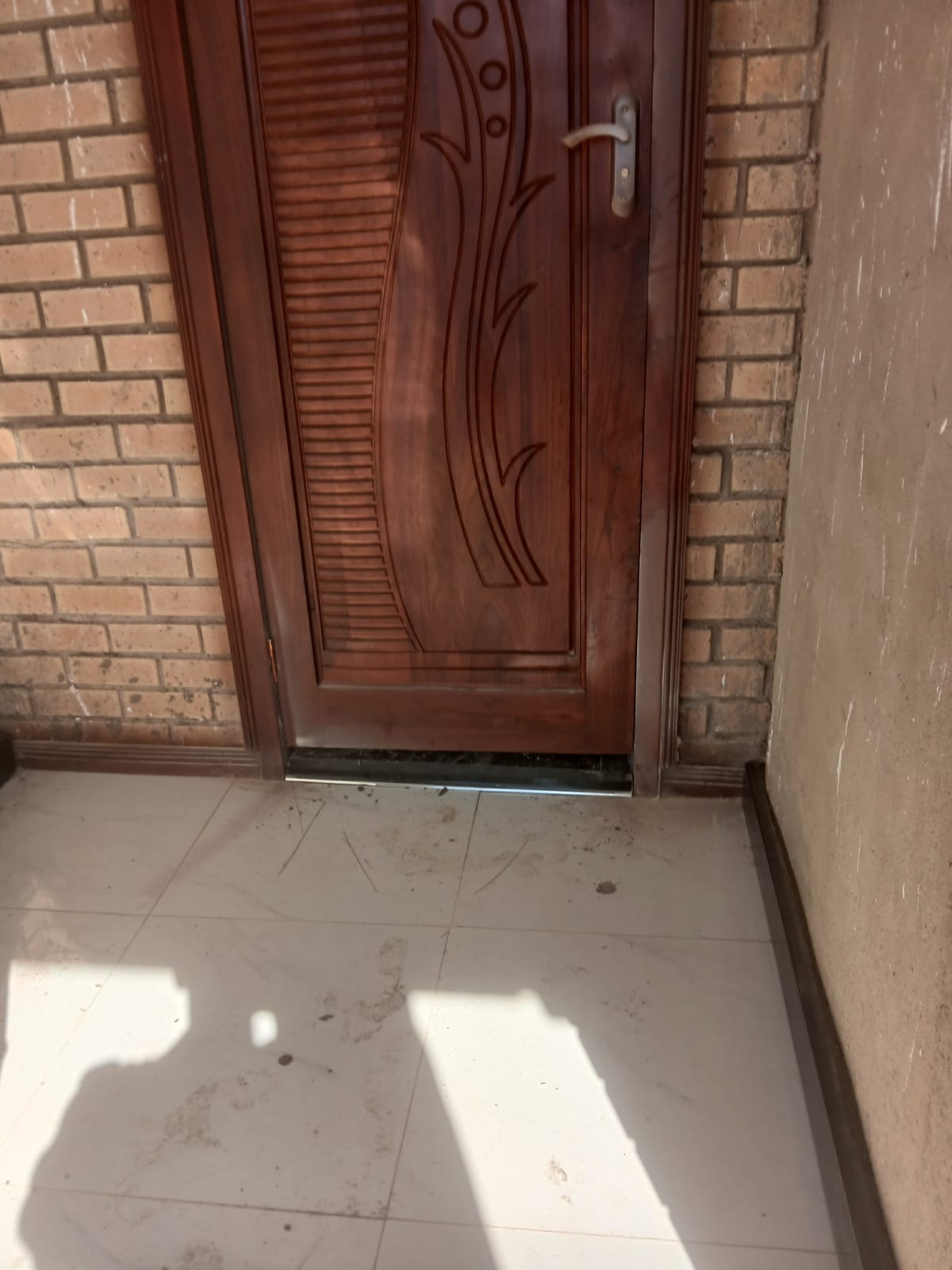 Installed entrance door with granite threshold and tiled floor